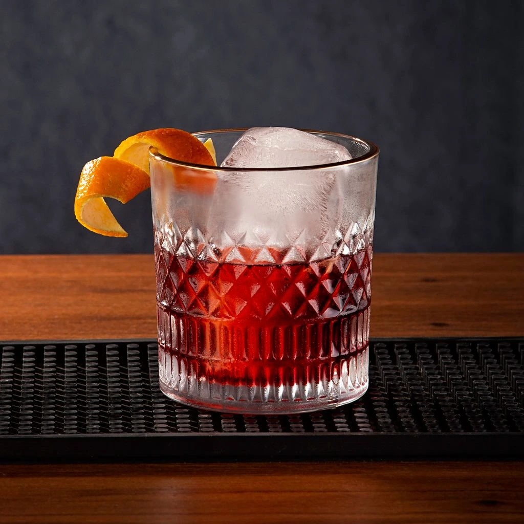 The Prado Negroni — bittered rum, vermouth, hibiscus — in a smoked coupe